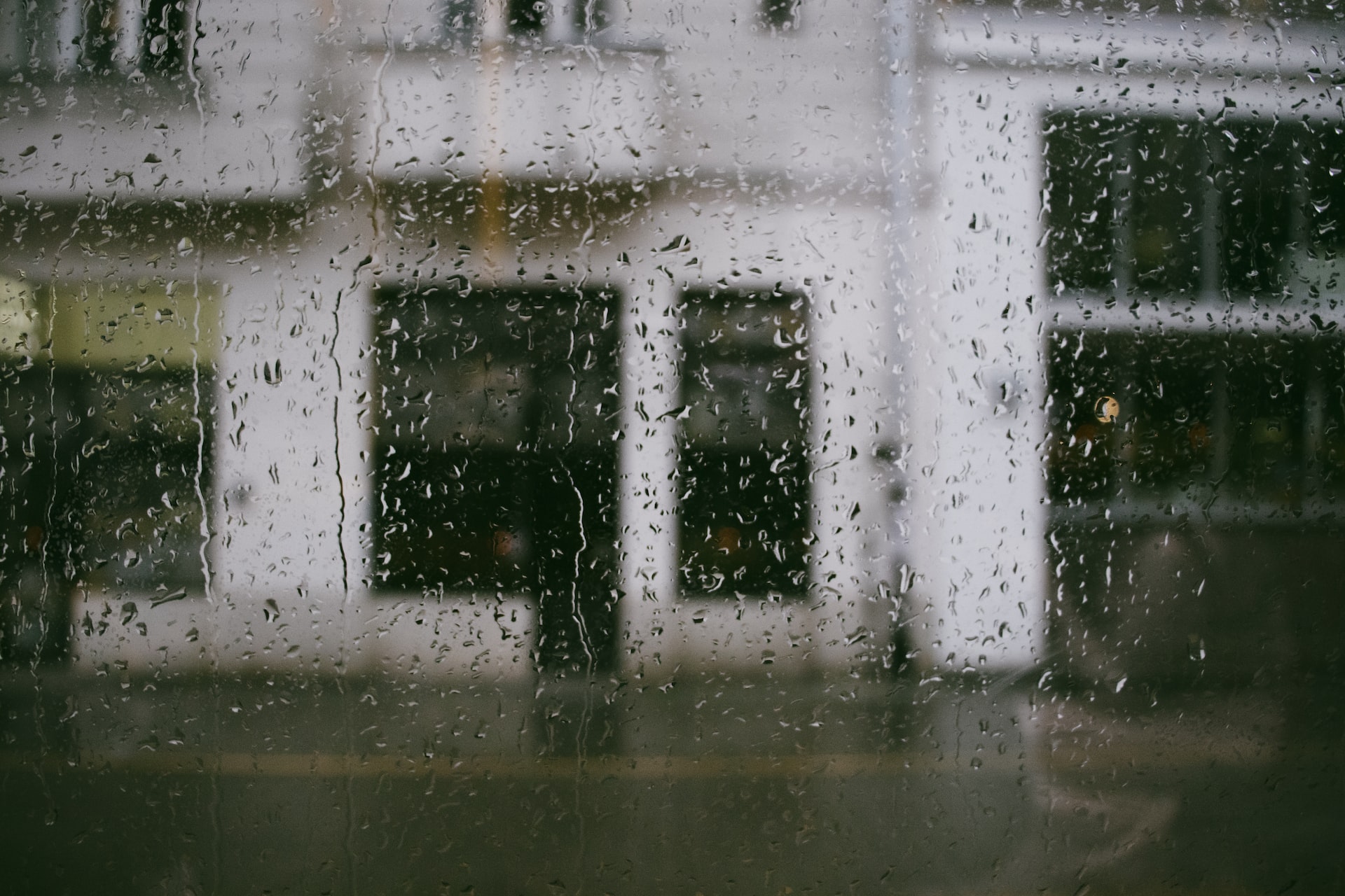 a rainy window with a building in the background
